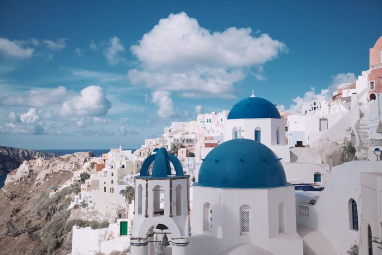 Białe domy i niebieskie kopuły kościołów w Oia na Santorini